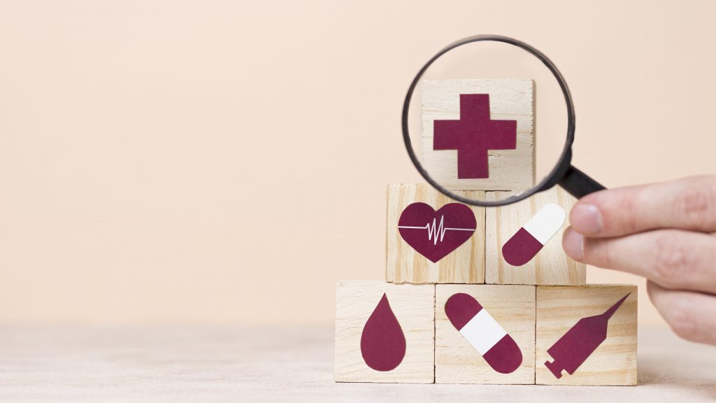 Kuusi puista kuutioita, joissa on lääketieteellisiä kuvia. Kuvat ovat purppuran värisiä.